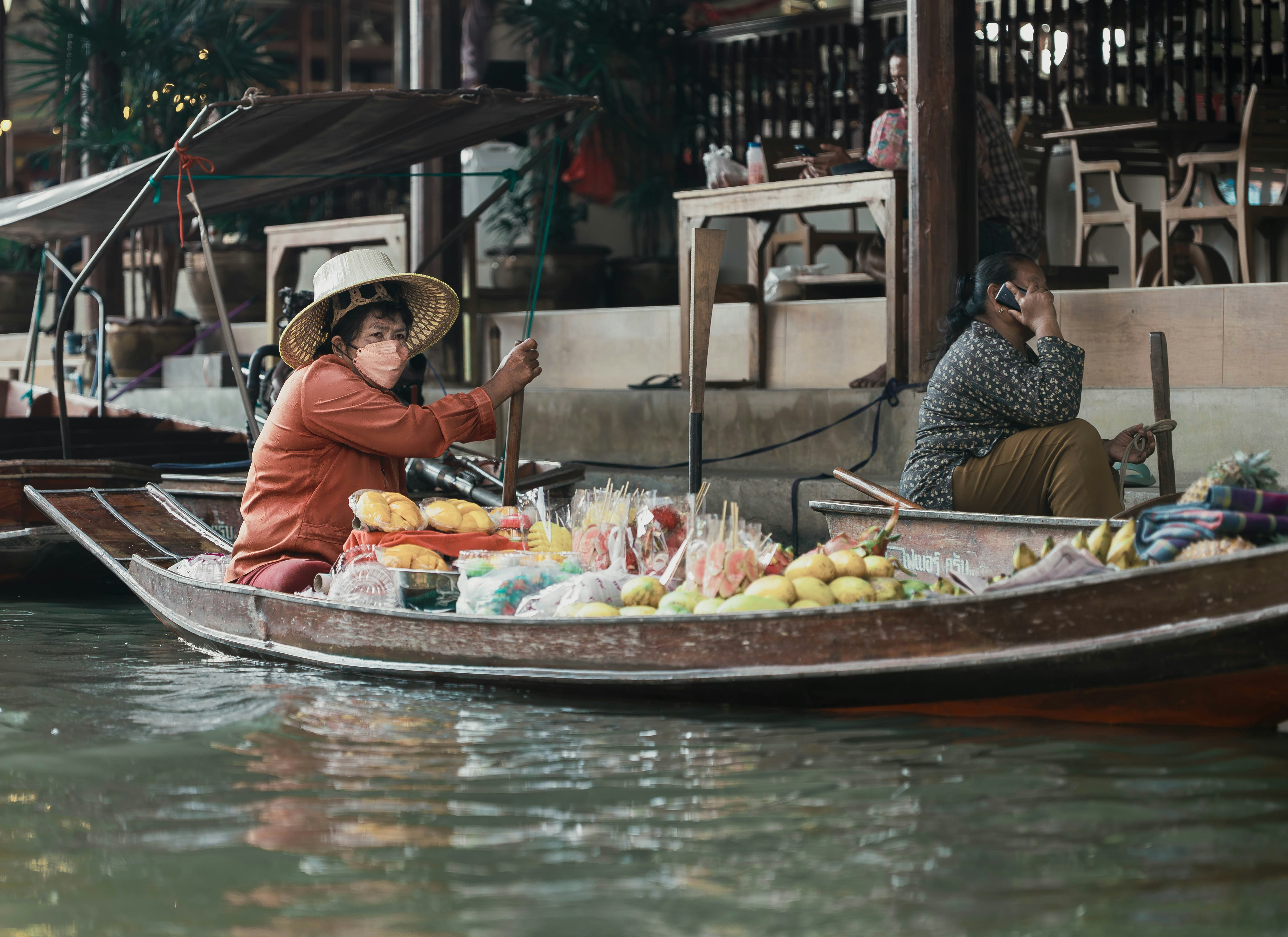 Woman selling fruit from a wooden boat at a floating market near Bangkok, Thailand