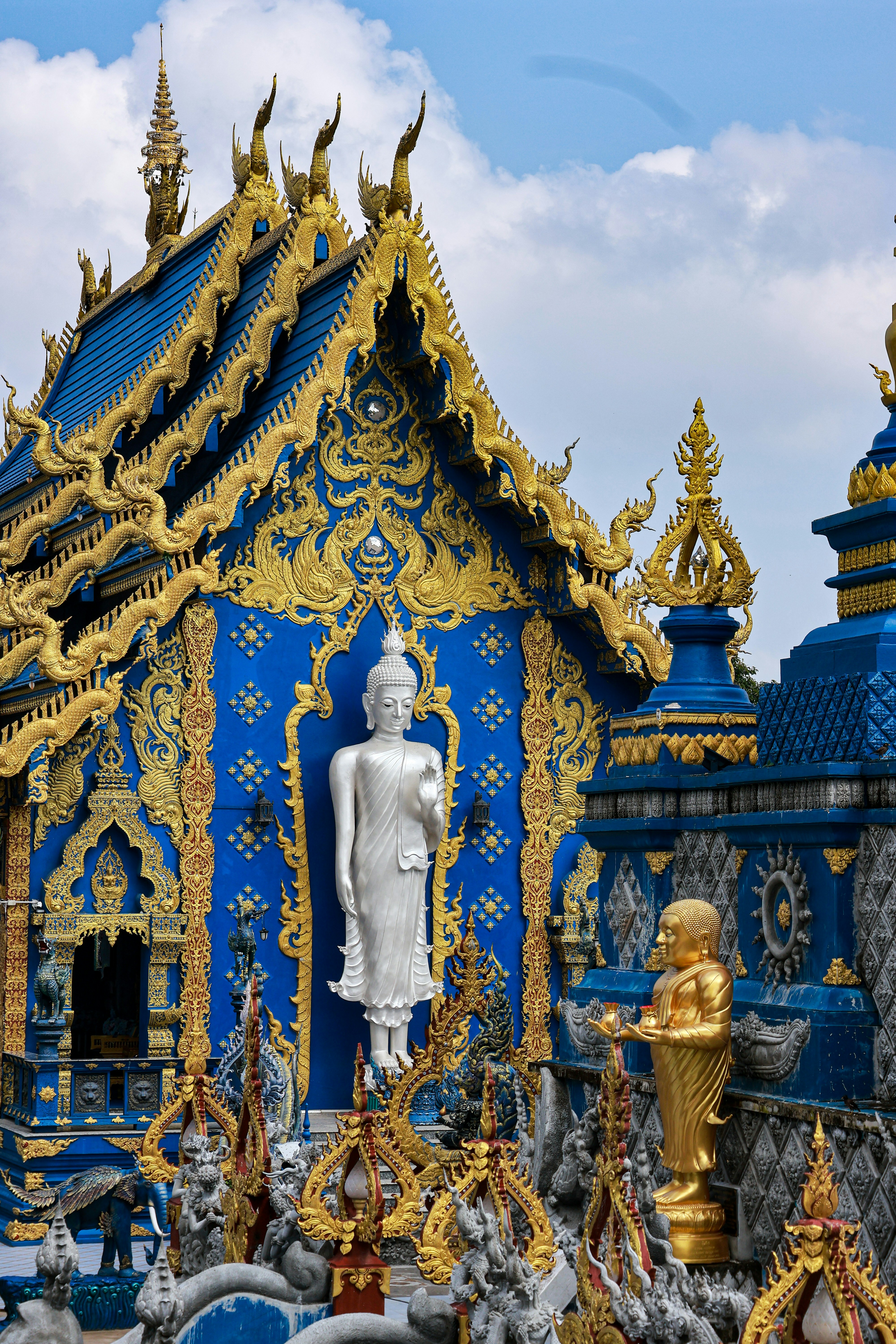 Blue Temple (Wat Rong Suea Ten) with ornate Buddha statues and golden detail, Chiang Rai, Thailand