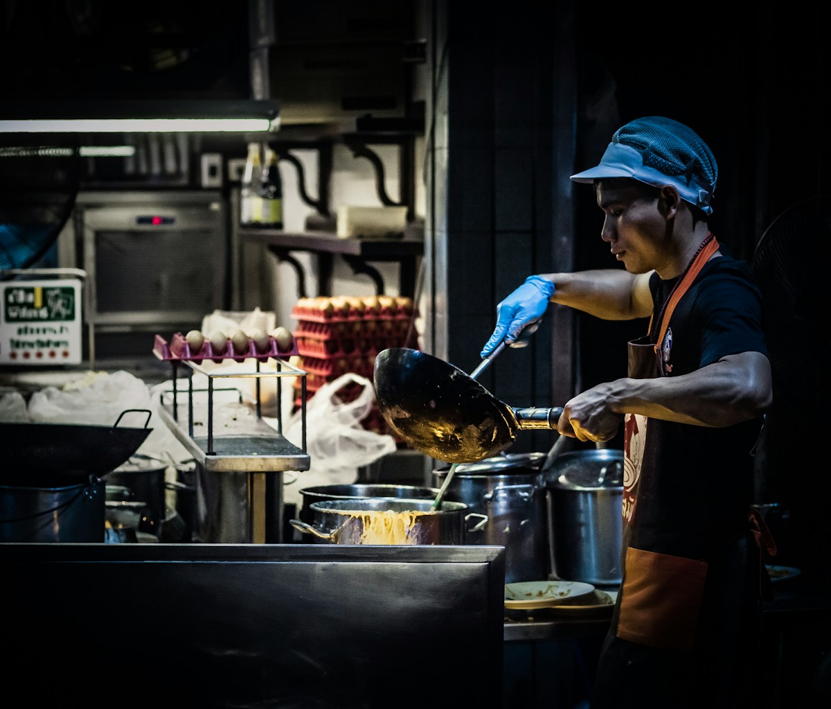 Wok stir-frying Thai food over a flame at a cooking class