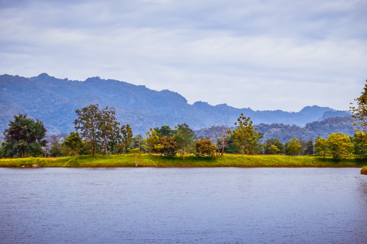 River with trees and mountains in the background, Chiang Rai province, northern Thailand