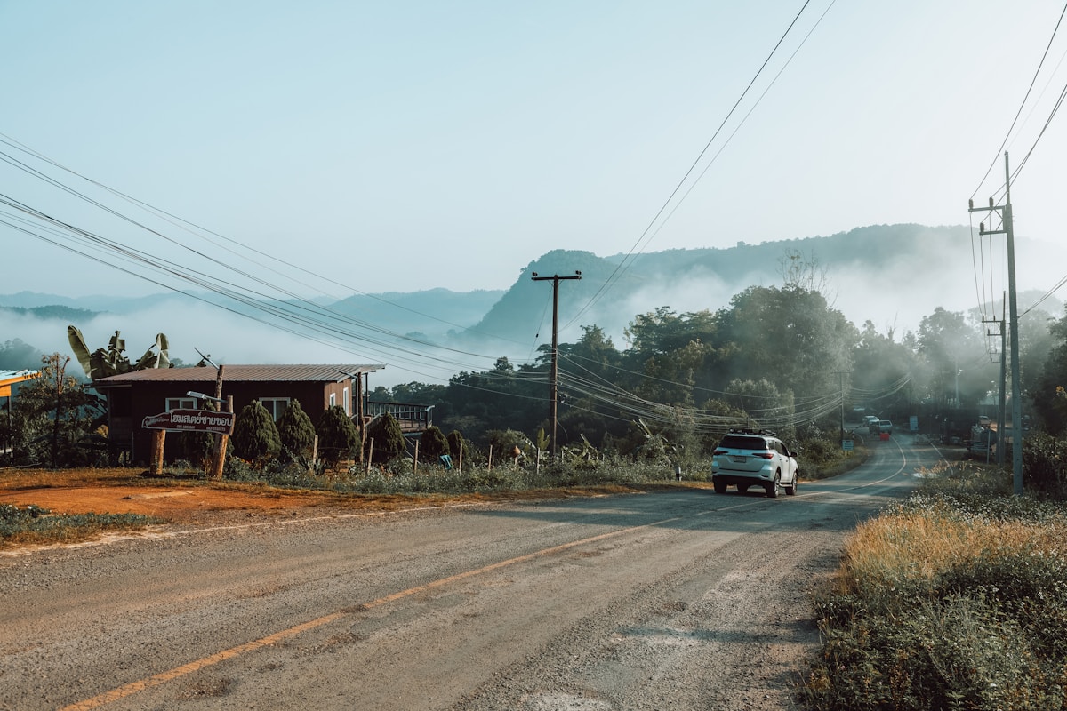 Car driving on misty mountain road at dawn through Pang Mapha district, Mae Hong Son province, Thailand