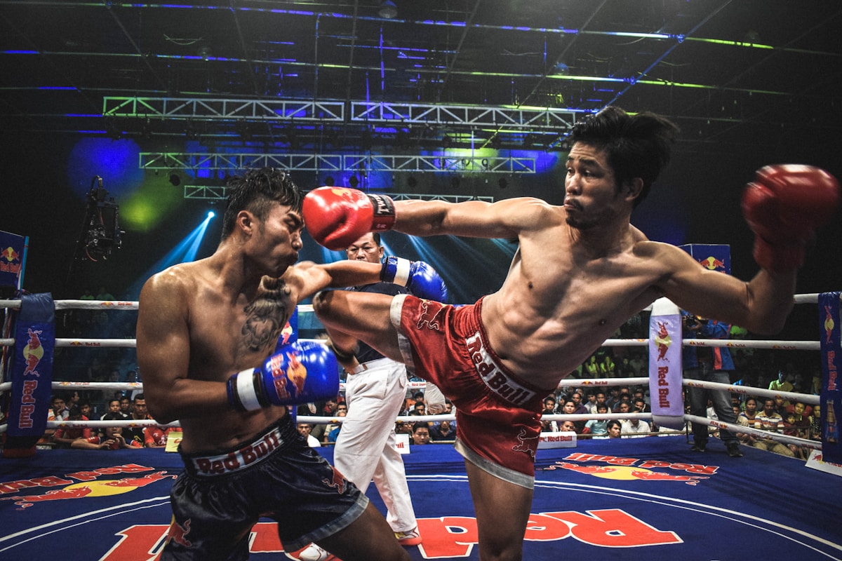 Muay Thai fighters in the ring under stadium lights