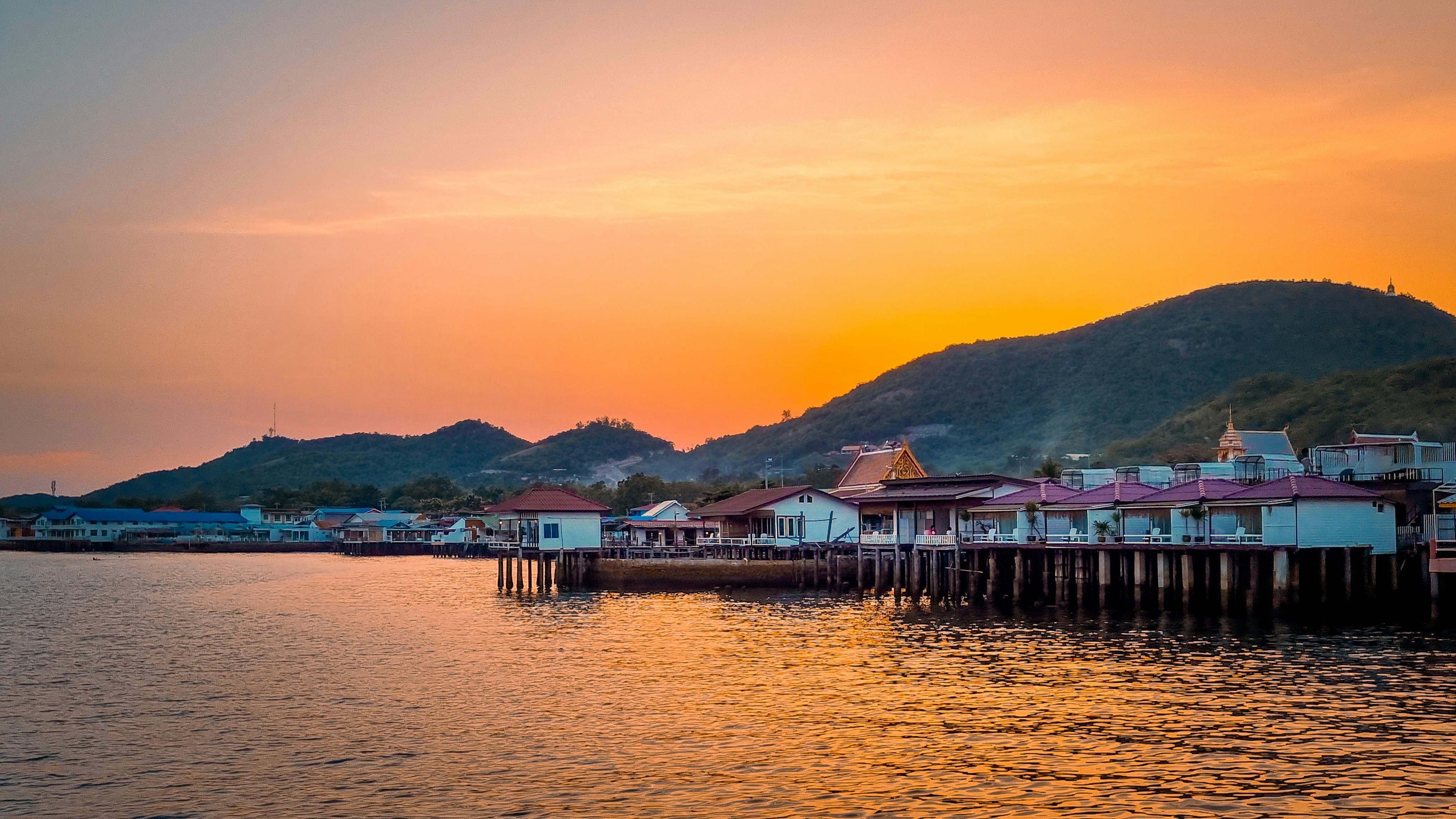 Traditional stilt buildings and pier on Koh Larn island at sunset, near Pattaya, Thailand