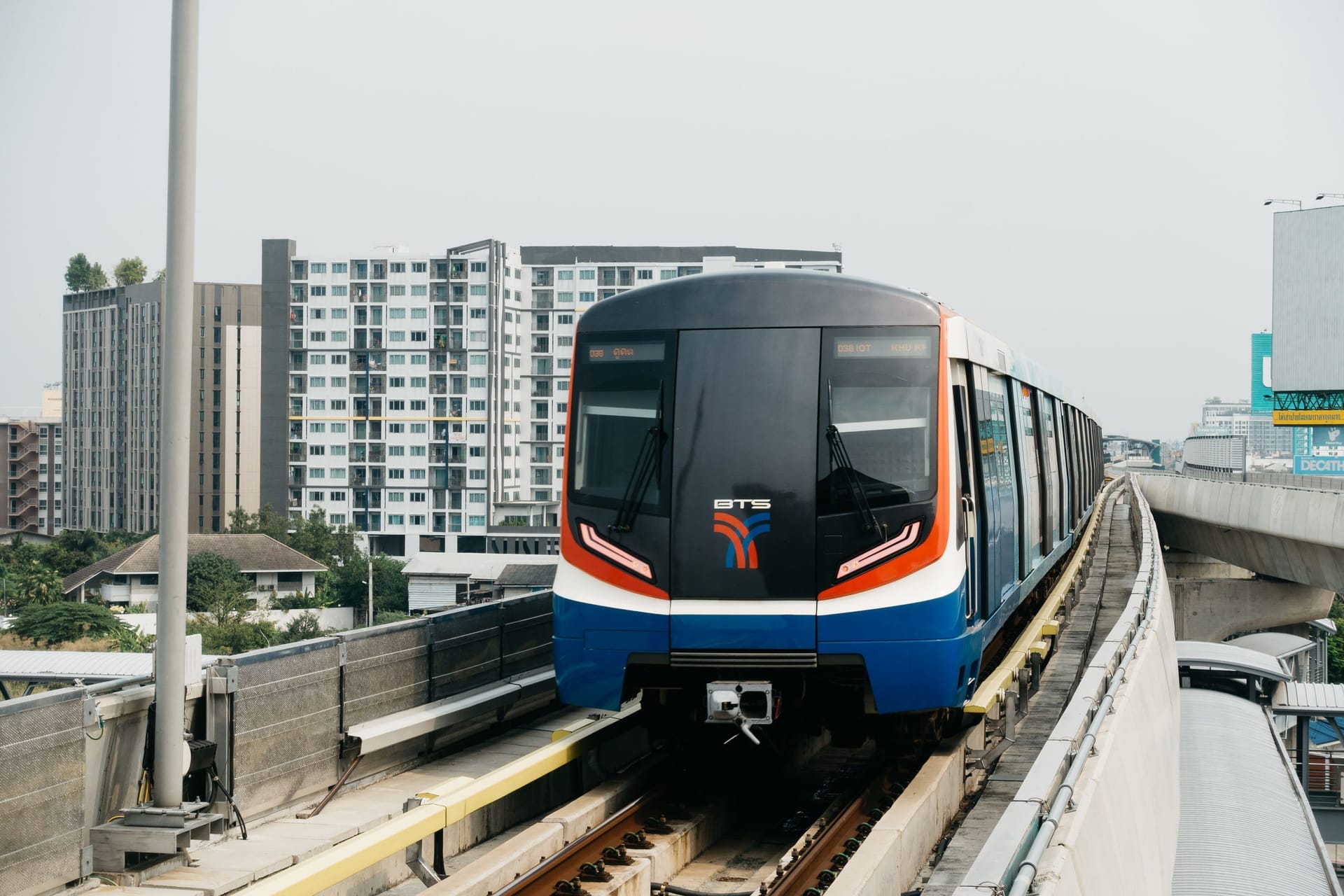 BTS Skytrain on elevated tracks approaching a station, Bangkok, Thailand
