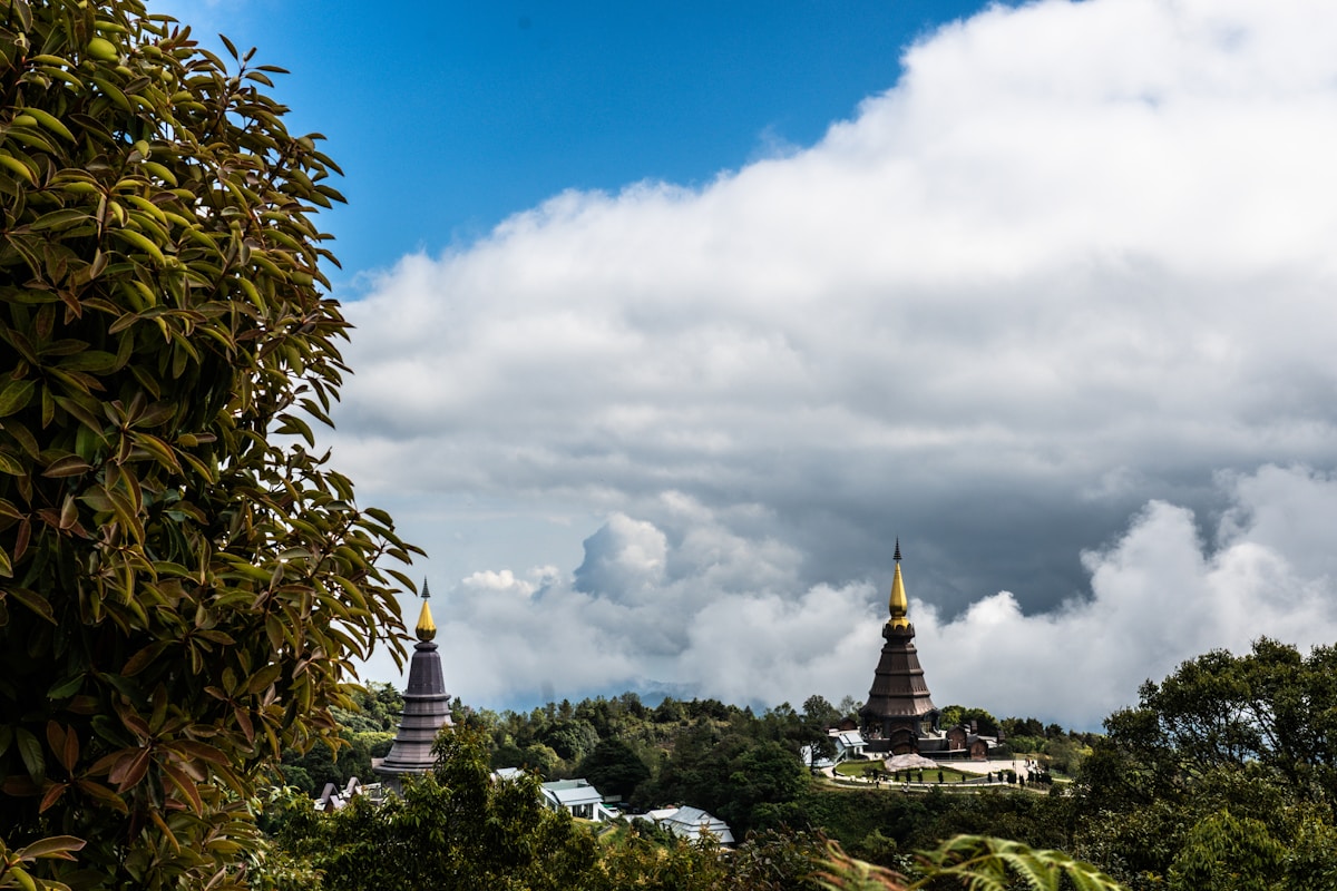 Twin chedis at Doi Inthanon National Park summit rising through cloud cover, Chiang Mai province, Thailand