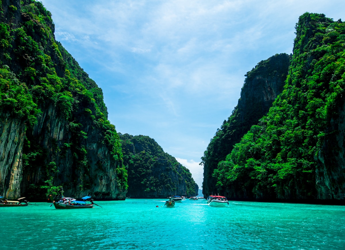 Boats in a narrow channel between towering limestone cliffs, Krabi Thailand
