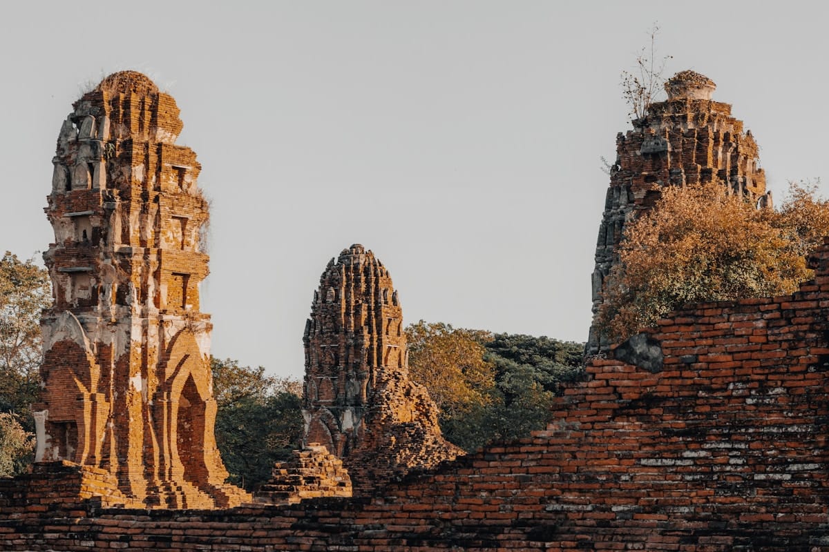 Ancient brick ruins with weathered stupas and greenery, Ayutthaya Historical Park, Thailand