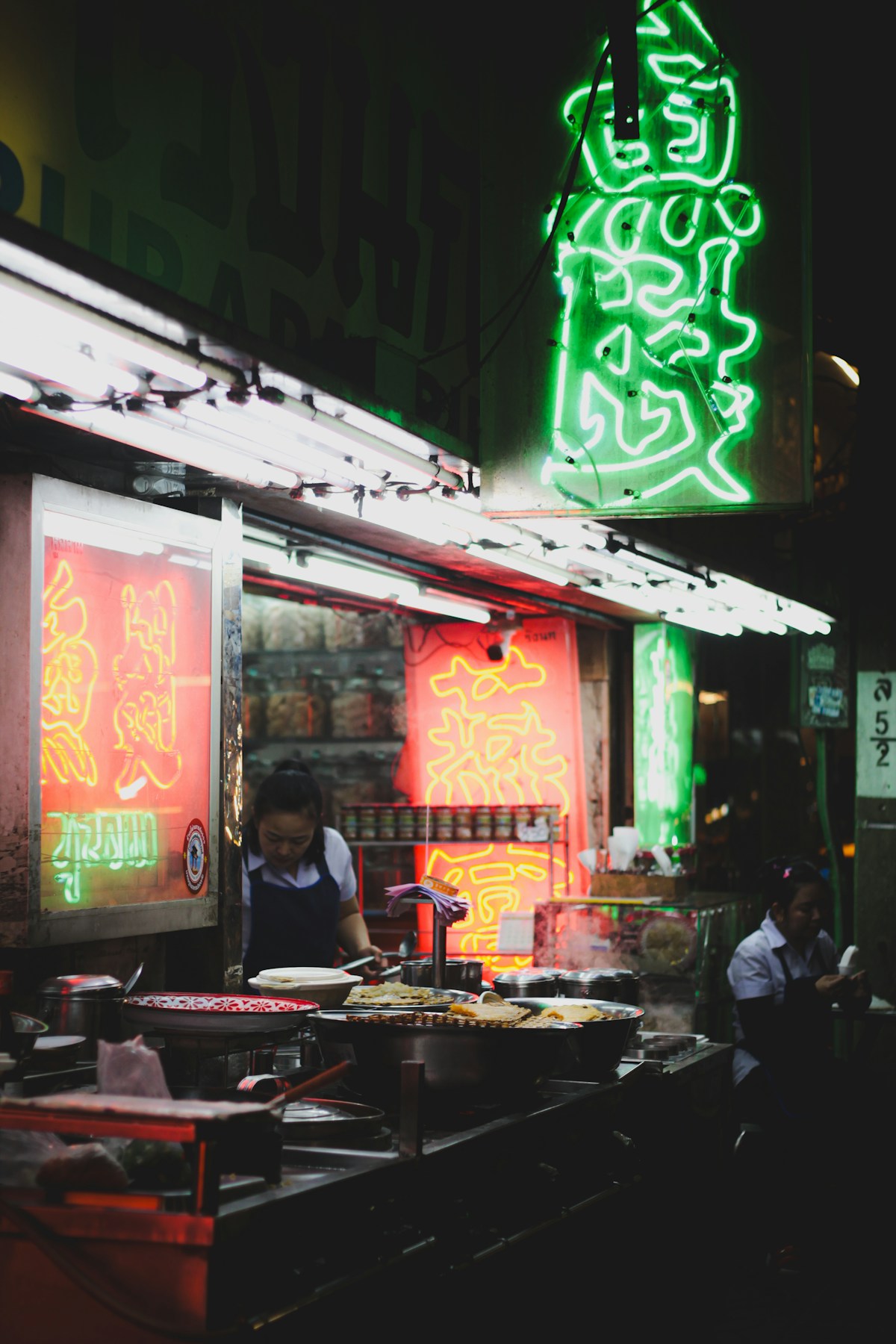 Street food vendor cooking in a wok at a Bangkok night market