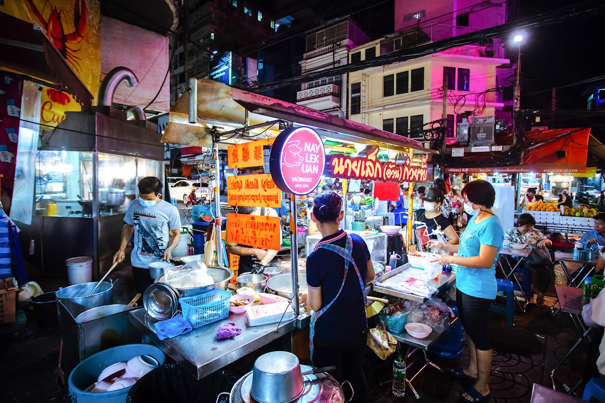 Vendors working at a Thai street food market at night, Bangkok