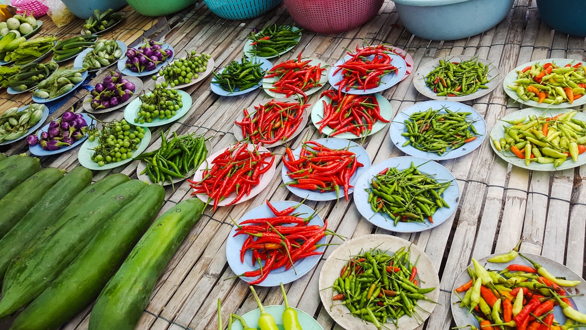 Colourful Thai vegetable curry and rice dishes on a wooden table