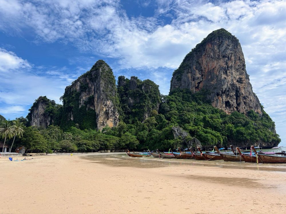Longtailboote unterhalb der Kalksteinfelsen am Railay Beach, Krabi