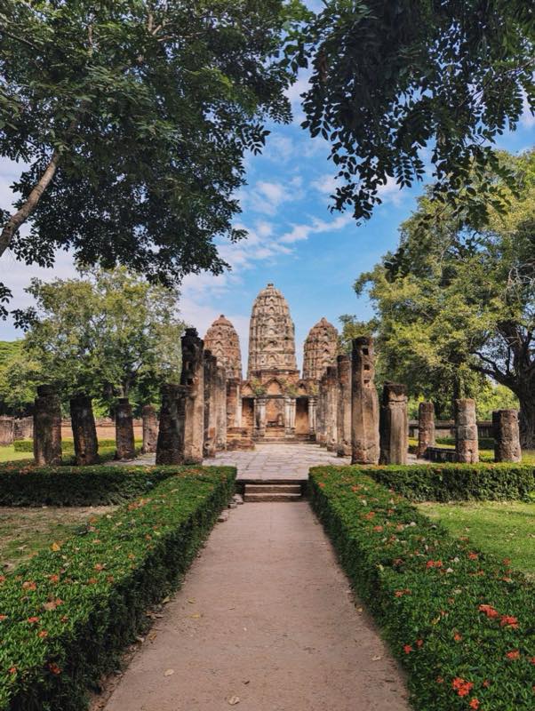 Ruine eines Prang im Khmer-Stil am Ende eines Gartenwegs, Geschichtspark Sukhothai