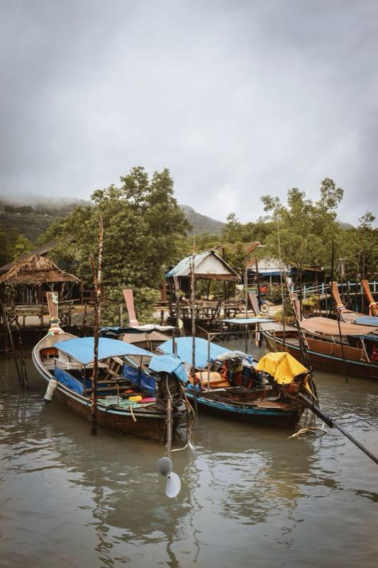 Longtail boats moored at a Surat Thani riverside dock