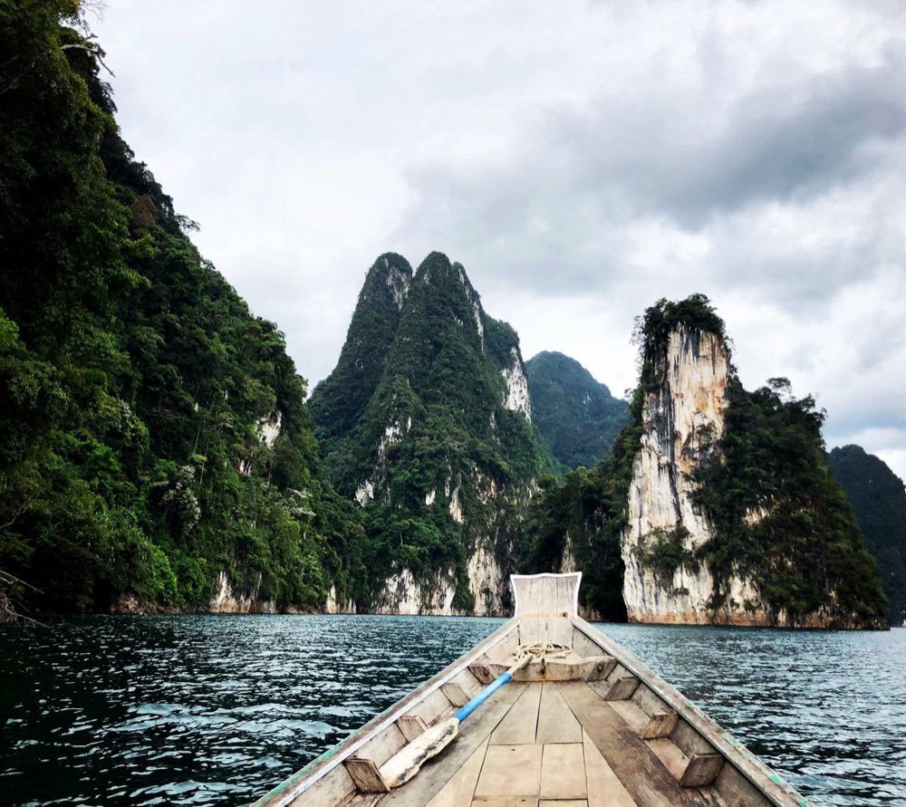 Proue d'un bateau longtail en route vers des pitons calcaires sur le lac Cheow Lan, parc national de Khao Sok