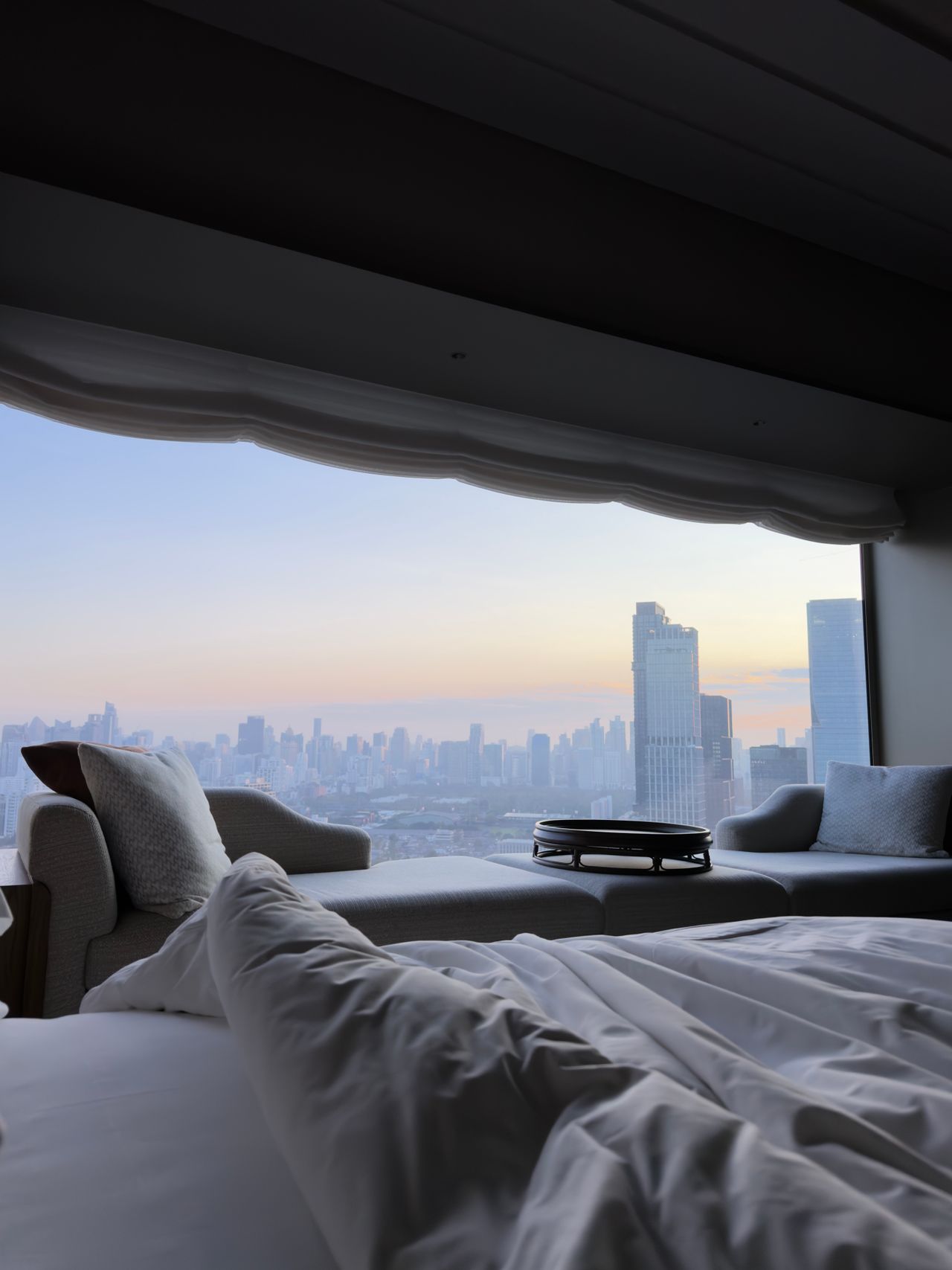 Hotelzimmer mit Blick auf die Skyline von Bangkok in der Dämmerung