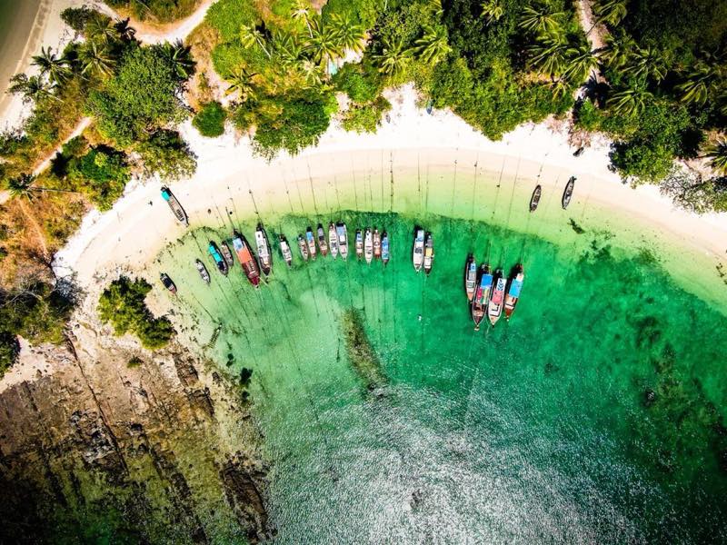泰国南部碧绿海湾中停泊的长尾船航拍