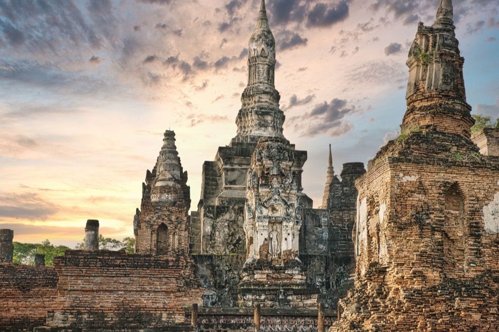 Backstein- und Stuck-Chedis im Geschichtspark Sukhothai bei Sonnenuntergang