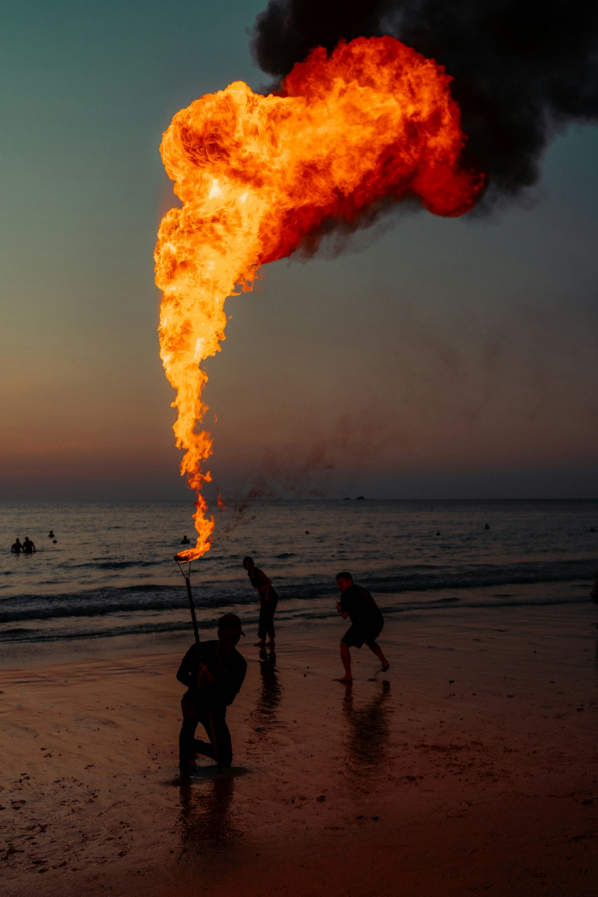 Fire show performer with massive flame on beach at dusk — Koh Phangan Full Moon Party entertainment