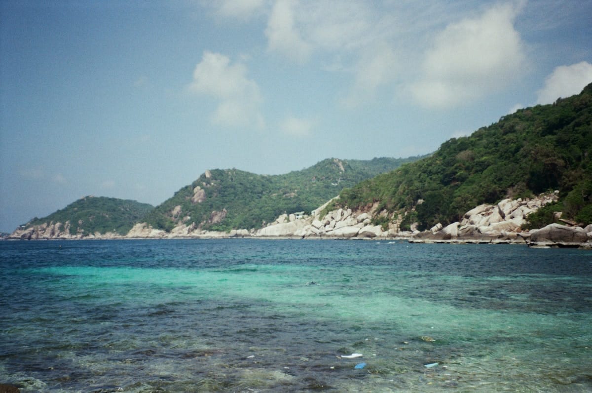 Scuba diver with tropical fish and coral reef in the Gulf of Thailand near Koh Tao