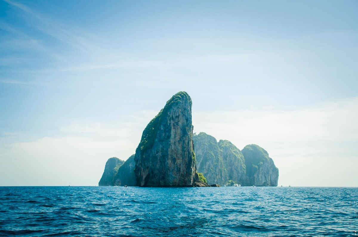 Limestone karst island rising from blue sea, southern Thailand