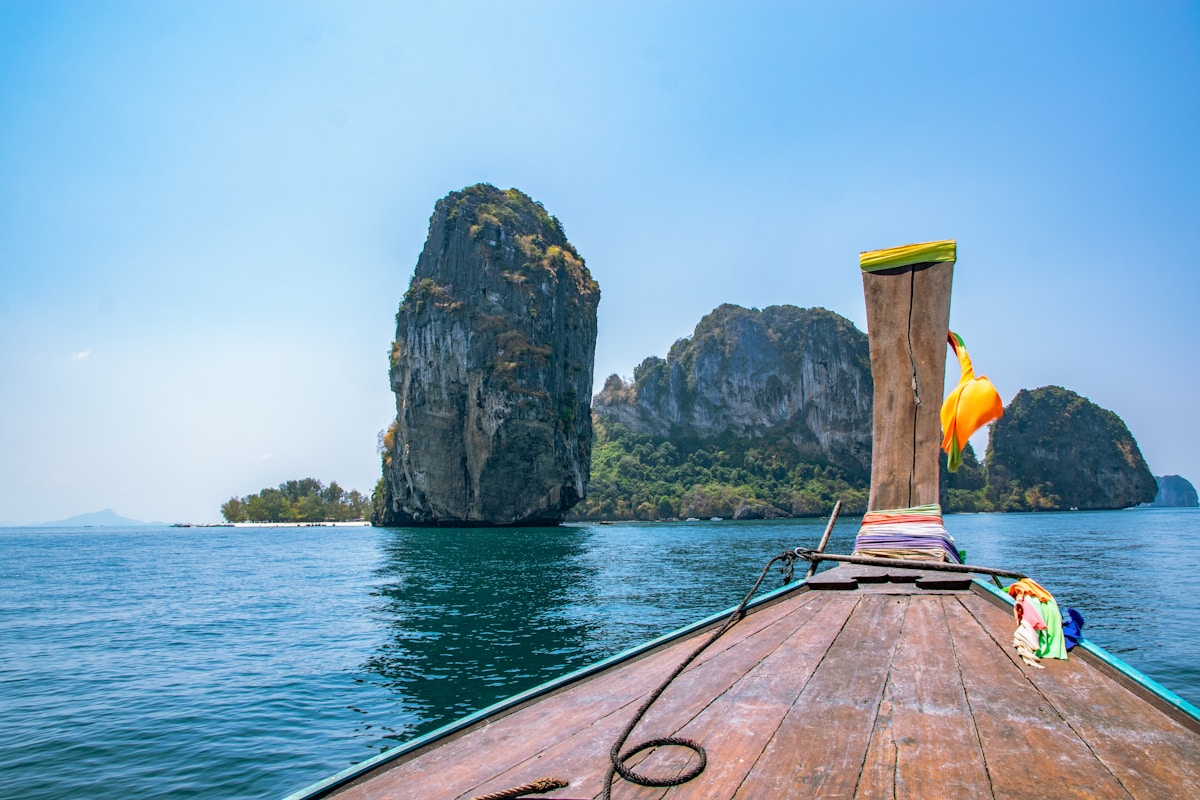 Longtail boat bow approaching limestone karst rock formations in the Andaman Sea, Krabi, Thailand