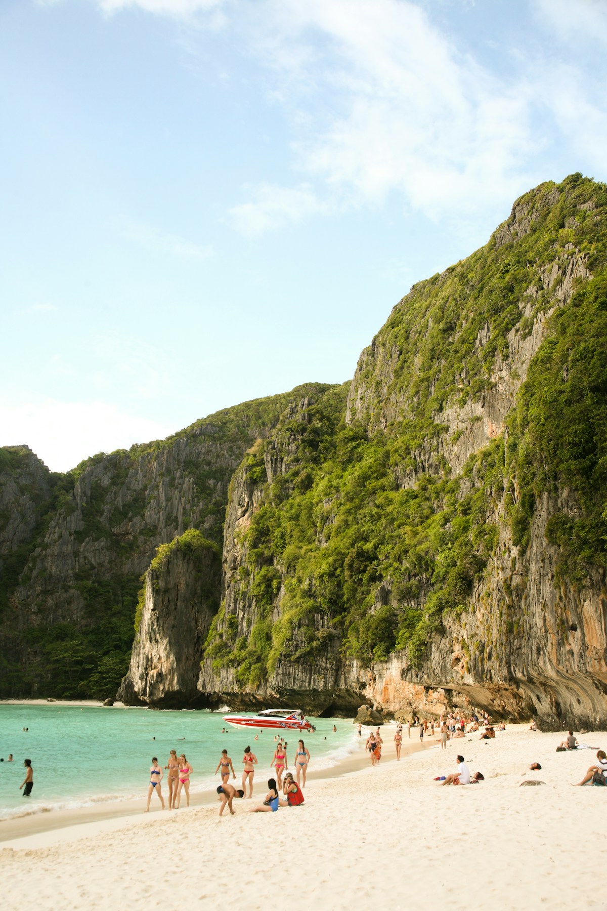 People on the beach at Koh Phi Phi Don with longtail boats and turquoise water, Krabi, Thailand