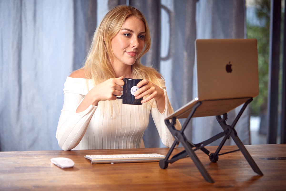 Woman working with coffee and laptop — remote work setup