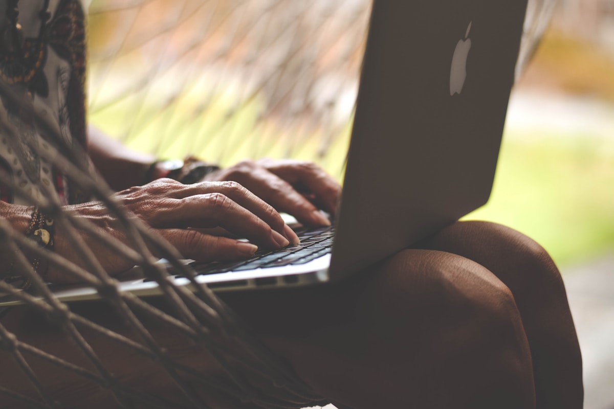 Person working on a laptop in a tropical outdoor setting — digital nomad lifestyle