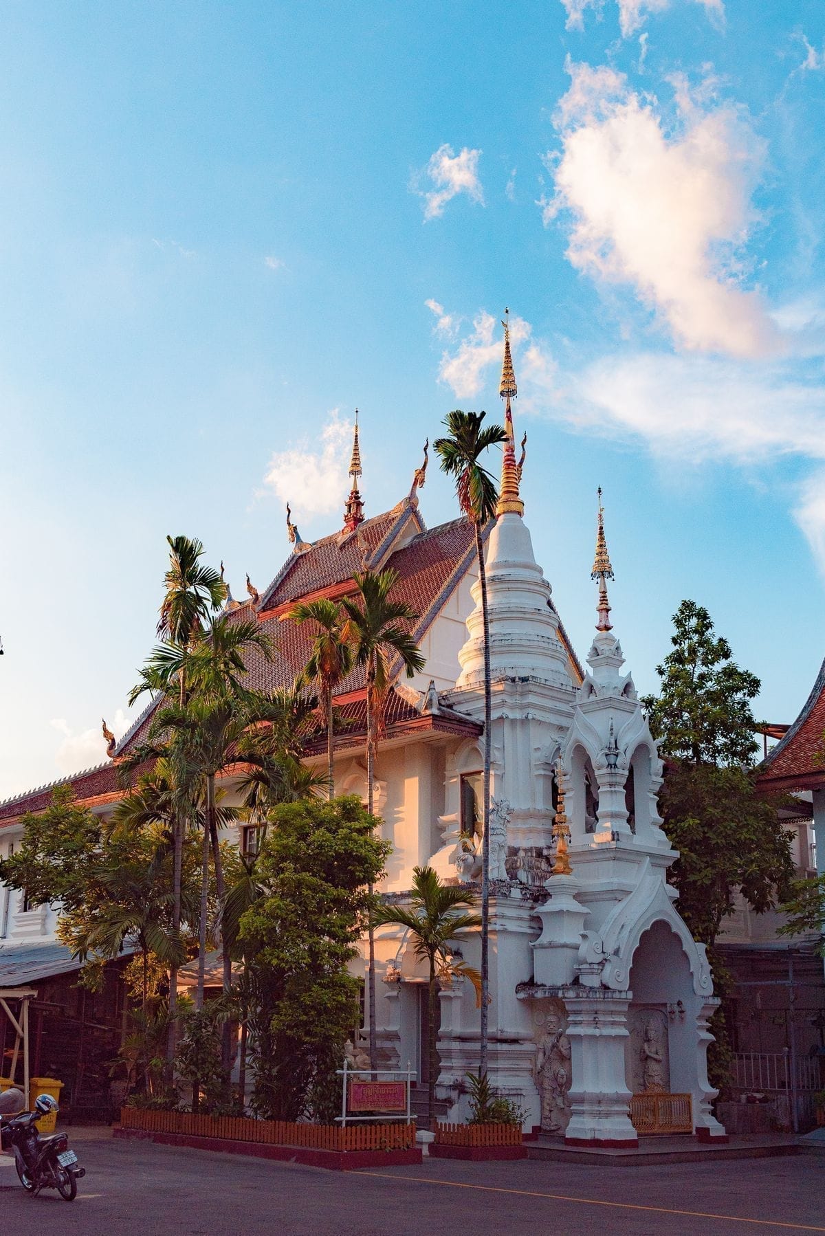 White Buddhist temple with golden spires at sunset in Chiang Mai, Northern Thailand