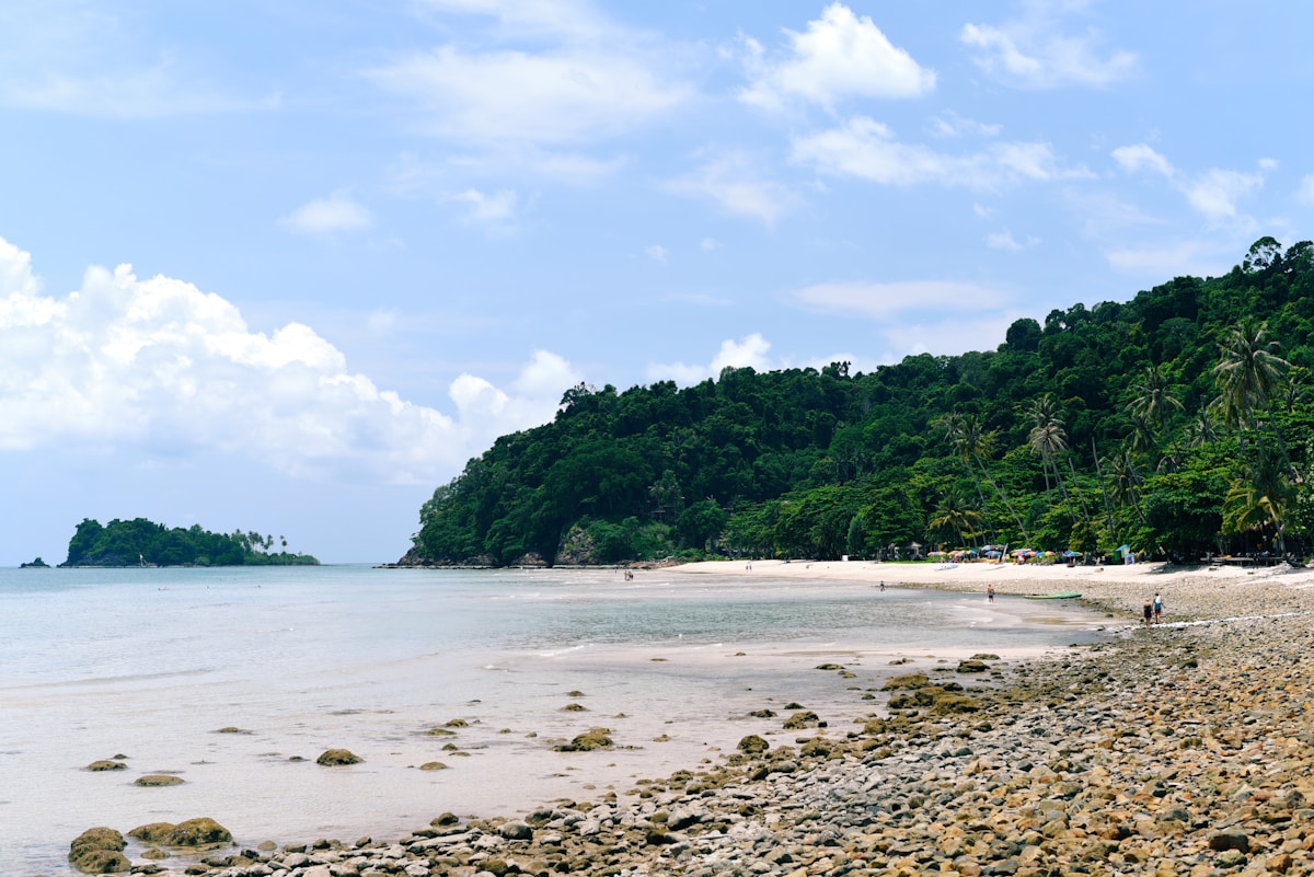 Sandy beach with lush jungle-covered hills, Koh Chang, Thailand