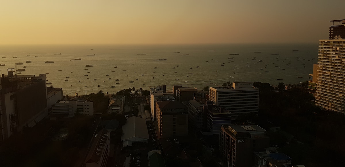Rooftop view of Pattaya city and bay at sunset with boats offshore, Chon Buri, Thailand
