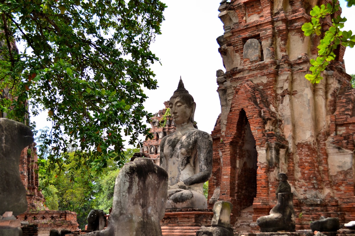 Ancient Buddha statue and brick prang ruins at Ayutthaya Historical Park, Thailand