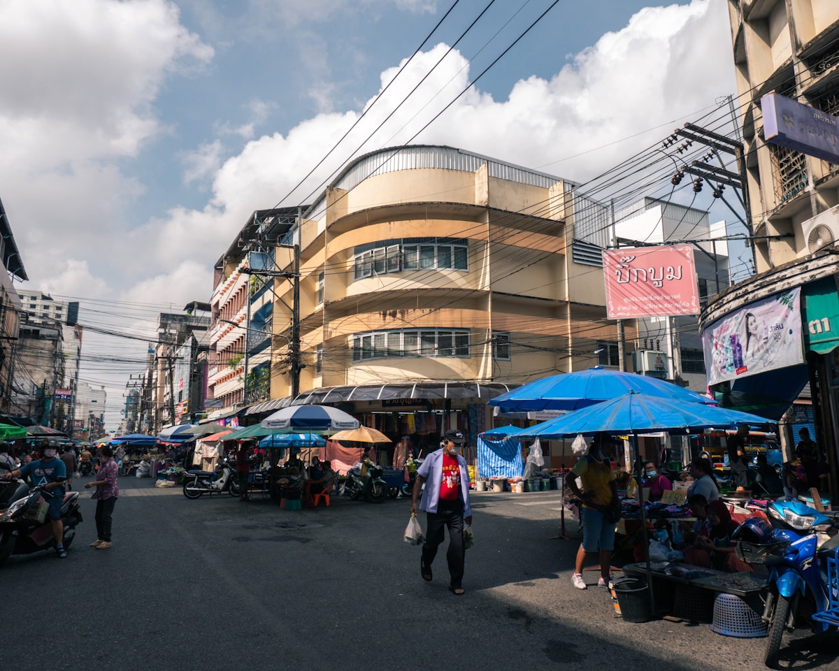Busy street market with blue umbrellas and shophouses, Hat Yai, southern Thailand