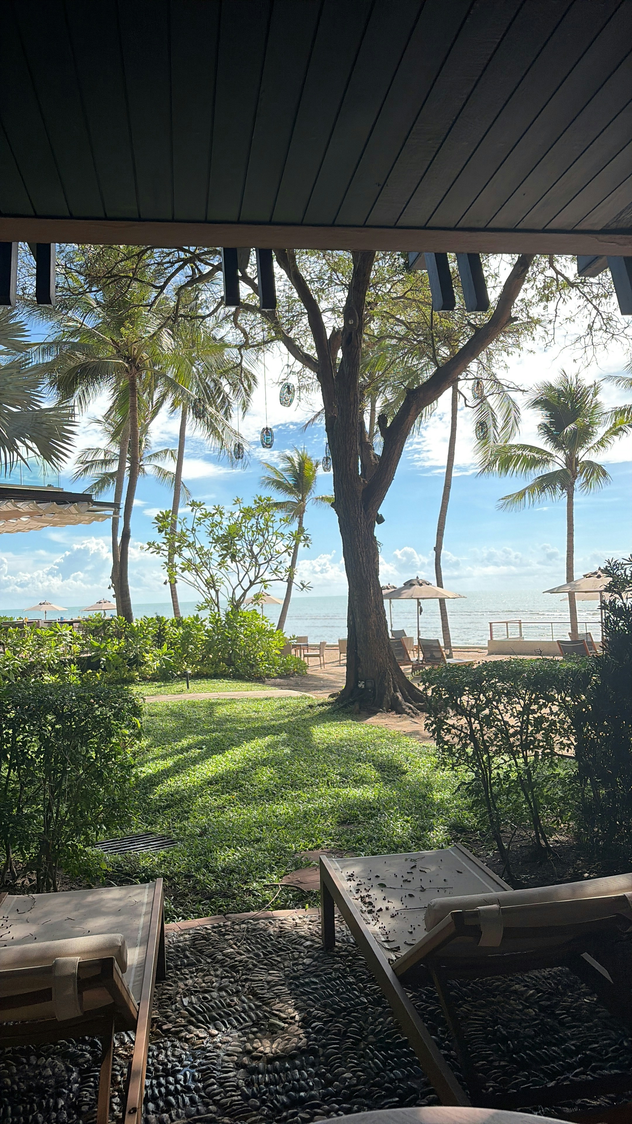 Shaded beachfront patio looking out through palm trees to the Gulf of Thailand, Hua Hin
