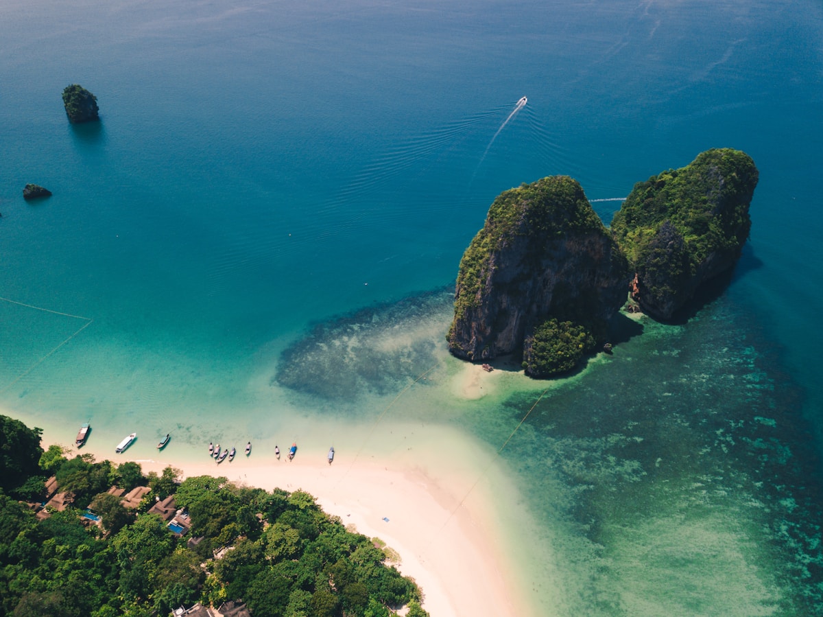 Longtail boats on Railay beach with limestone cliffs, Krabi